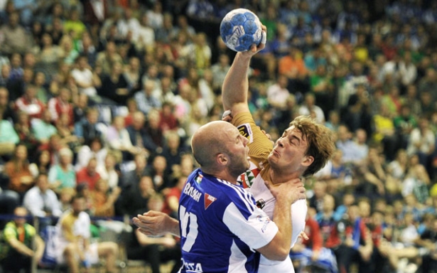 Balogh Zsolt (kékben) keményen ütközik egy berlini játékossal az EHF kupa elődöntőjében (Fotó: MTI/EPA/DPA/Daniel Naupold)