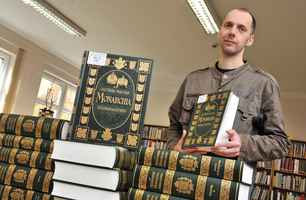 Buzai Csaba könyvtárigazgató mutatja a 21 kötetes sorozatot (Fotó: Rajki Judit)