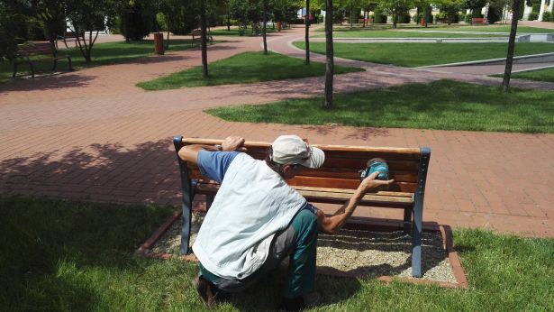 Csiszolás után lazúrral festik le a padokat a Főtéren (Fotó: OrosCafé)